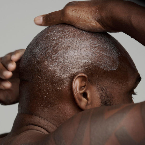 black man shaving his head with frederick benjamin shaving products