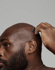 black man shaving his head using frederick benjamin easy primer, best pre shaving primer for black men, best non greasy shaving primer for men of color