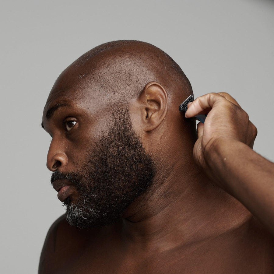 black man shaving his head with frederick benjamin shaving products